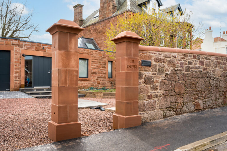 Newly built red sandstone pillars and stone boundary wall