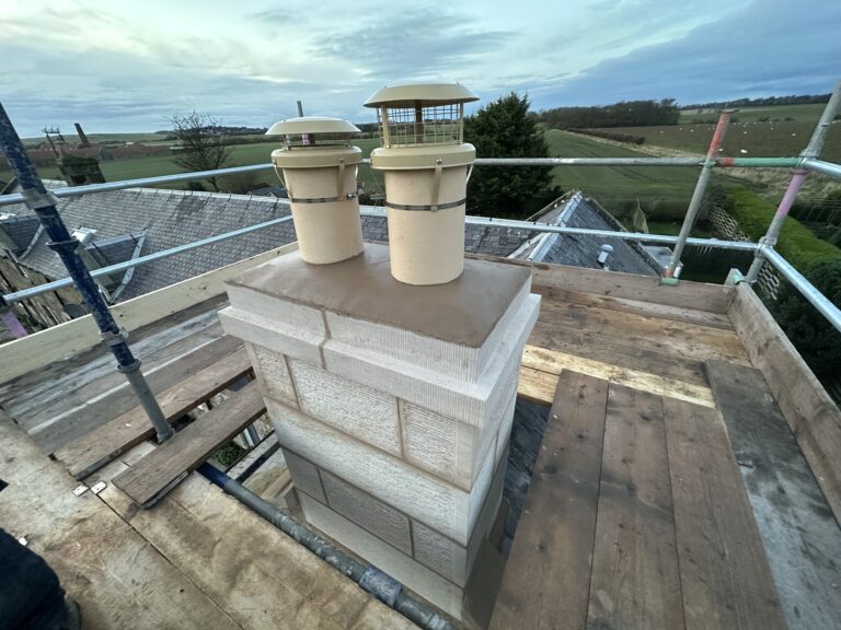 Rebuilt sandstone chimney stack with clay pots, seen from the scaffold
