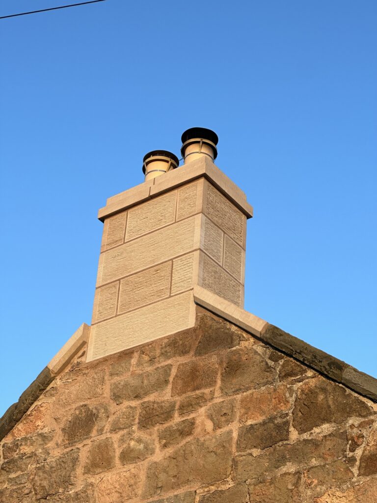 Rebuilt sandstone chimney stack on a gable end