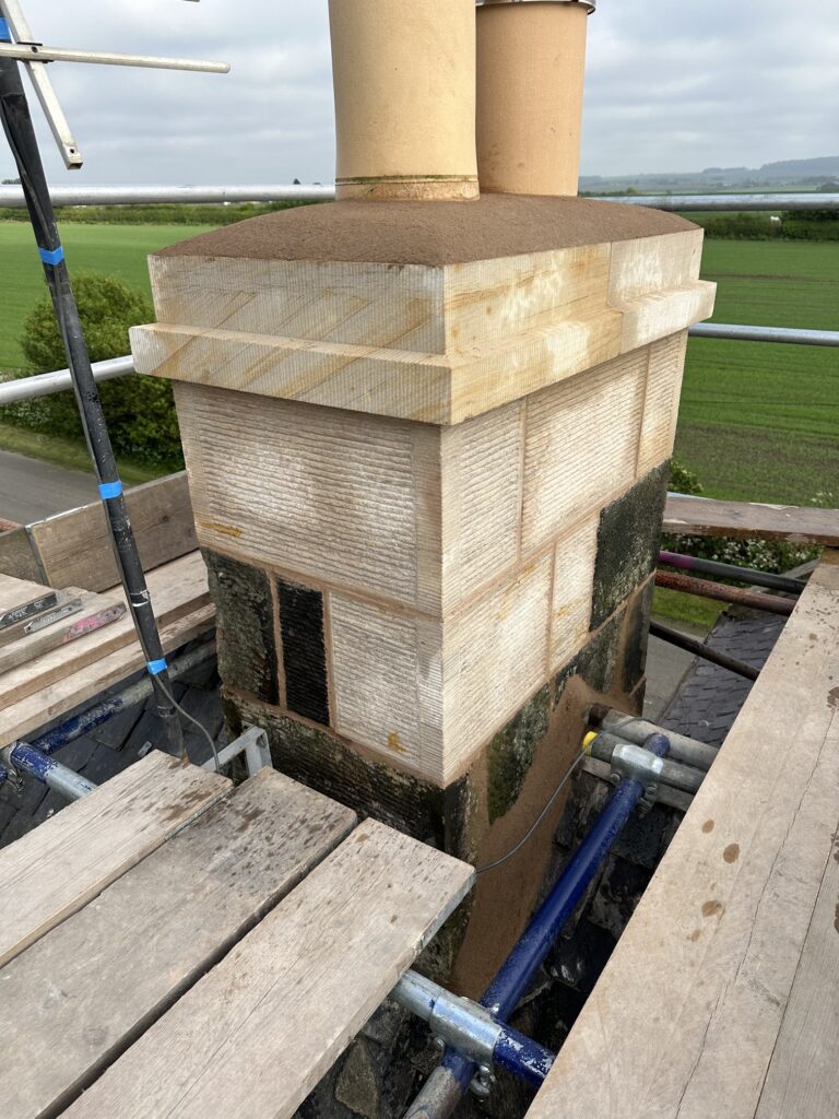 Rebuilt sandstone chimney stack with two buff chimney pots