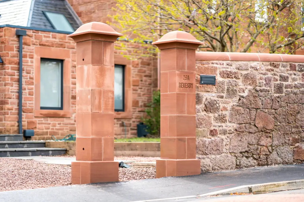 New red sandstone gate pillars and rubble stone boundary wall